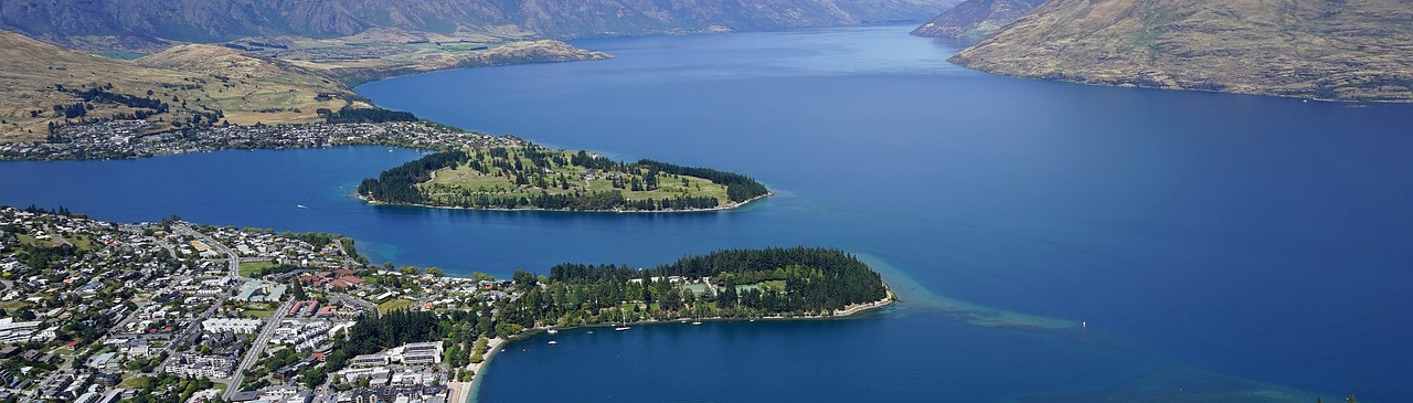 Ausschnitt der Stadt Queenstwon mit Seen und Bergen im Hintergrund